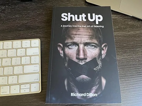 A copy of Shut Up by Richard Dillon on a desk beside a keyboard